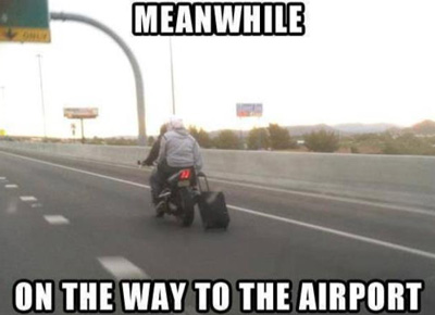 towing a suitcase behind a motorbike